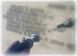 Photo of worker inscribing names of alumni veterans.